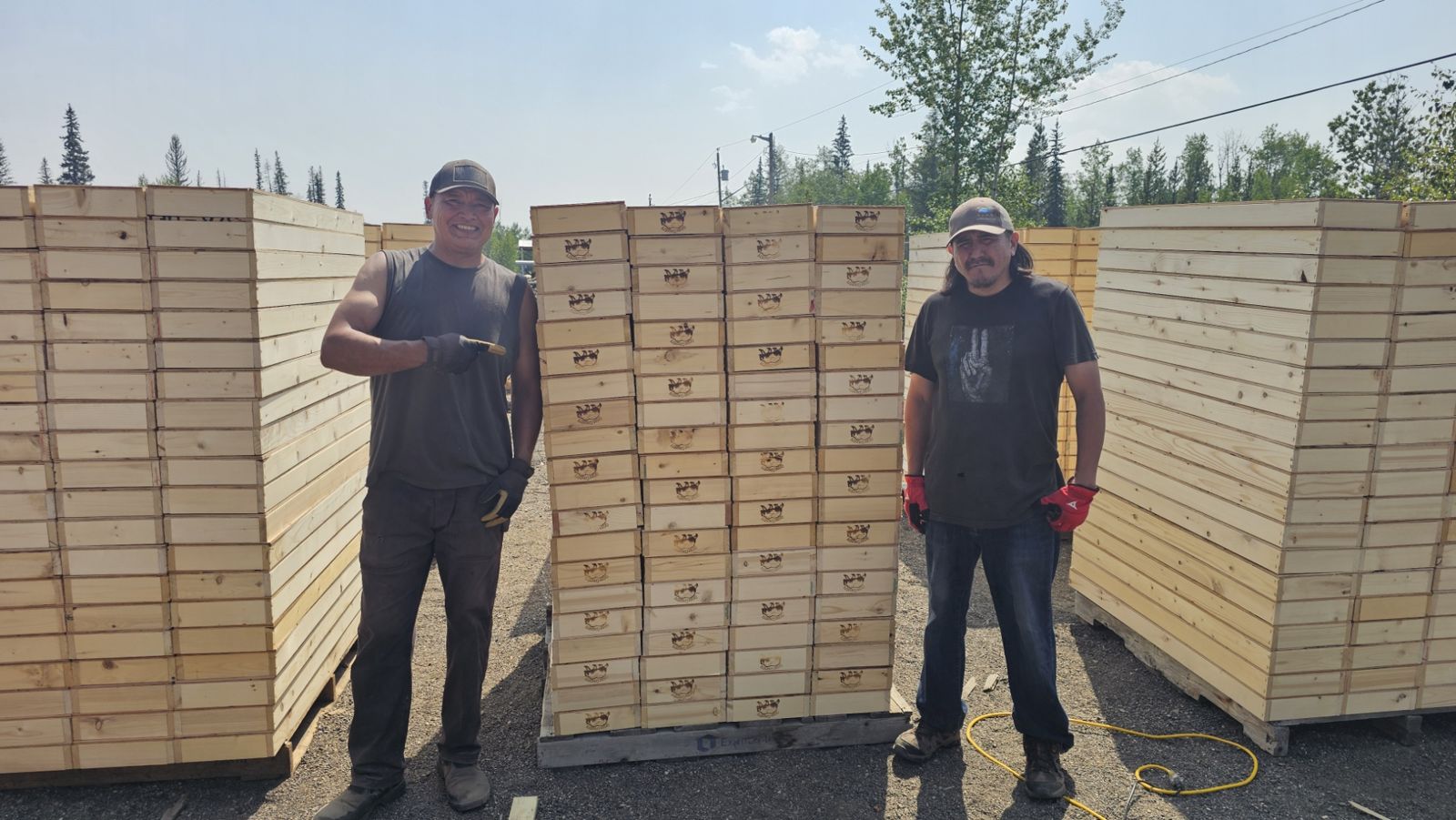 Two crew members standing beside pallets of stacked core boxes